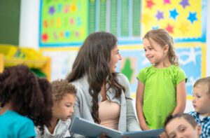 The teacher is giving positive affirmations to the kids to help them build a daily positive mindset.